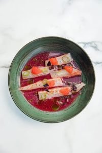 Présentation d'un plat à base de Crudo Daurade dans le restaurant ADMA